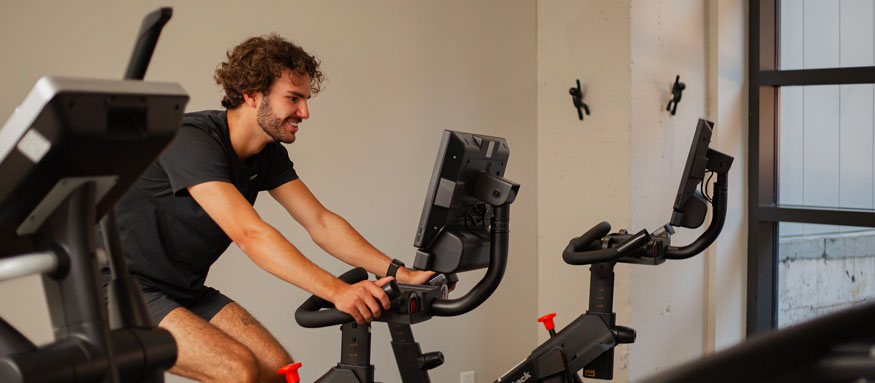 Homme sur un vélo | Gym | NordicTracker | Vélo | Tapis roulant