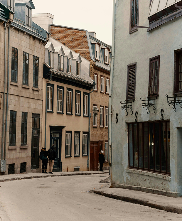 Rue pittoresque du Vieux-Québec avec façades historiques colorées et passants — ambiance urbaine authentique. Près de Monsieur Jean