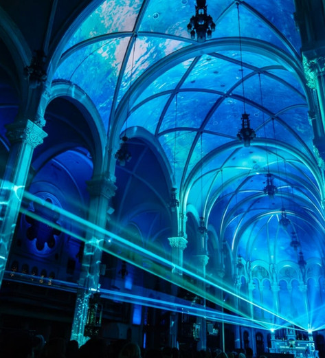 AURA immersive multimedia experience at Saint-Roch Church in Québec, featuring light projections on the interior architecture.