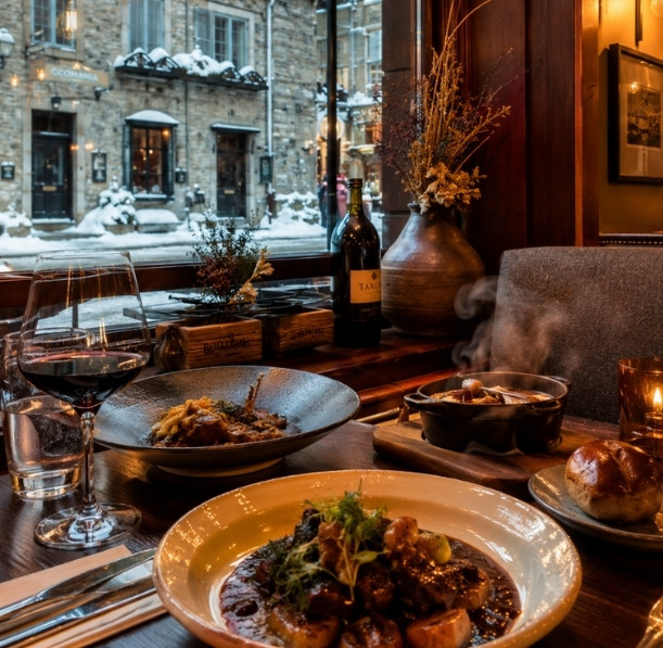 Dining table at a restaurant in Old Québec during winter, featuring seasonal Québec cuisine in a warm and inviting atmosphere.