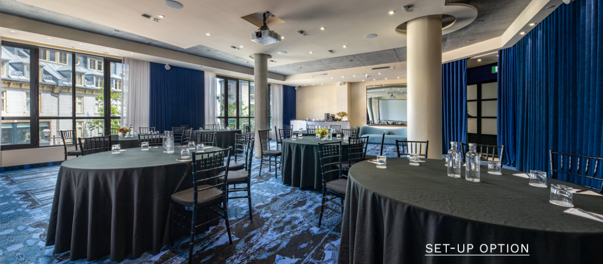 Half-moon conference room with projection screen and natural light at Hôtel Monsieur Jean in Old Québec.