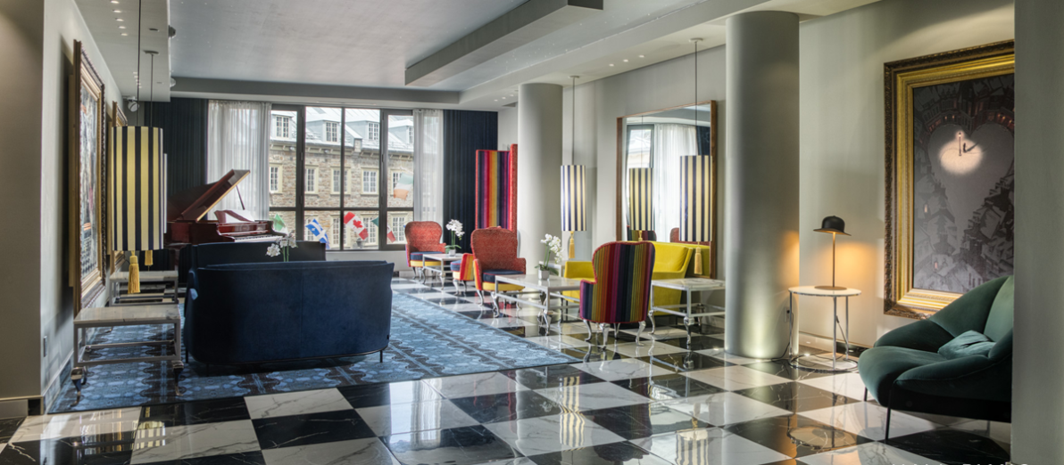 Hall Piano de l'Hôtel Monsieur Jean avec piano à queue, mobilier design et grandes fenêtres dans le Vieux-Québec.