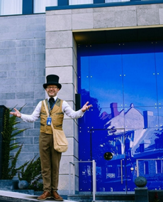 Guide privé de Monsieur Jean accueillant les visiteurs devant l'hôtel dans le Vieux-Québec avant une visite guidée.